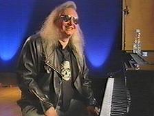 Jim Steinman, sitting at a piano and smiling