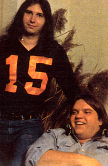 Jim Steinman (left) in a sports jersey, Meat Loaf (right) seated