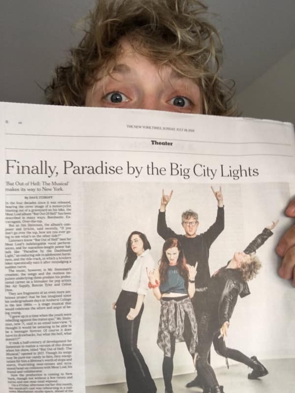 Andrew Polec holding a copy of this news article
